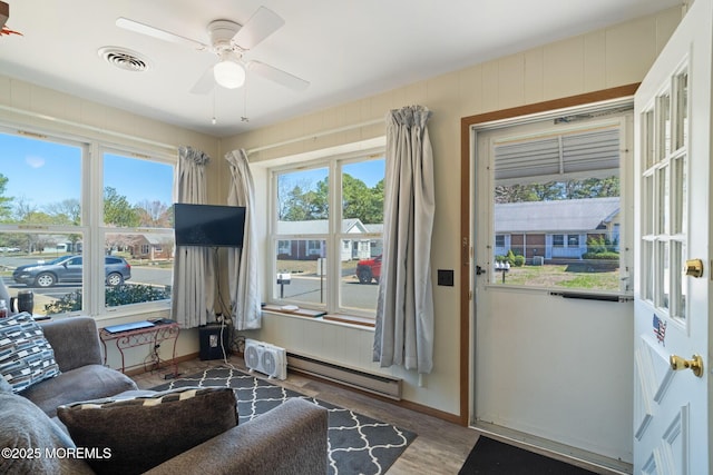 doorway to outside with wood finished floors, visible vents, a baseboard heating unit, baseboards, and ceiling fan