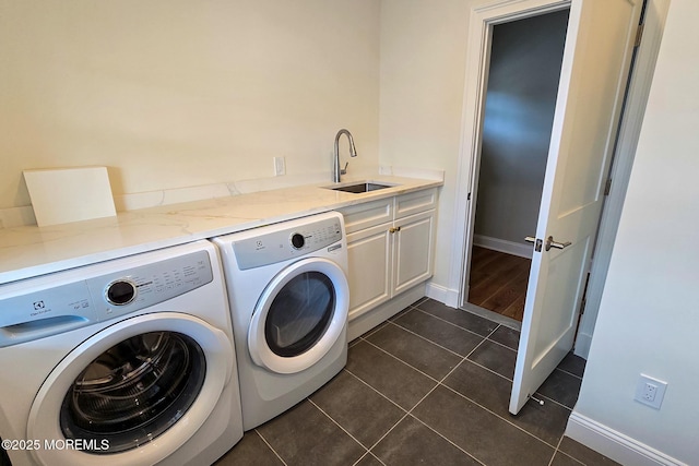 clothes washing area featuring washer and clothes dryer, cabinet space, baseboards, and dark tile patterned floors