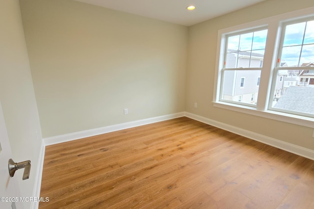 empty room with healthy amount of natural light, light wood-style flooring, baseboards, and recessed lighting
