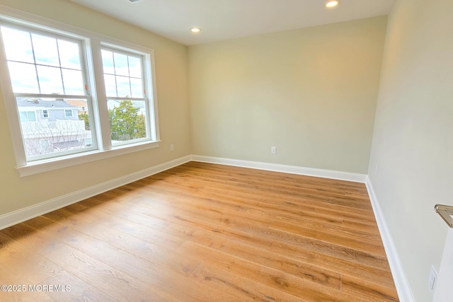 unfurnished room featuring wood finished floors, baseboards, and recessed lighting