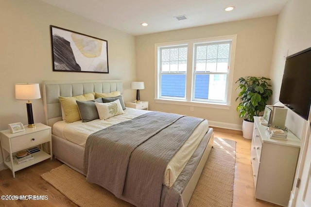 bedroom with light wood finished floors, recessed lighting, and baseboards