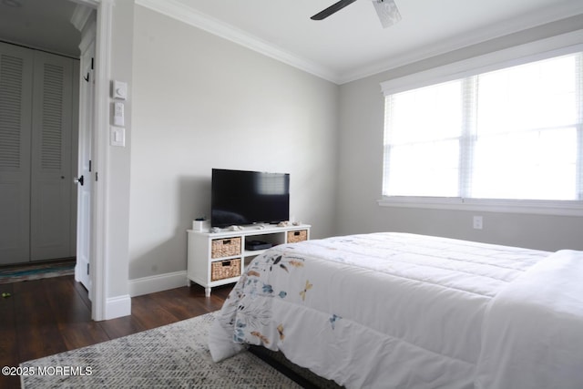 bedroom with a closet, ceiling fan, baseboards, ornamental molding, and dark wood-style floors