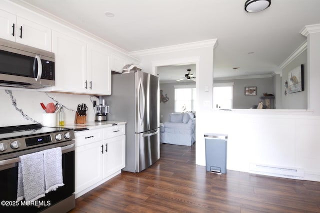 kitchen featuring a baseboard heating unit, white cabinetry, a ceiling fan, appliances with stainless steel finishes, and ornamental molding