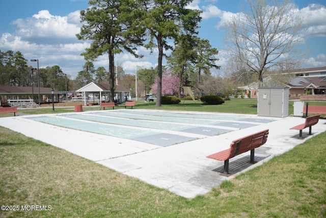 view of home's community featuring a lawn and shuffleboard