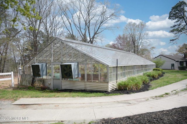 view of home's exterior with fence, an outbuilding, and an exterior structure