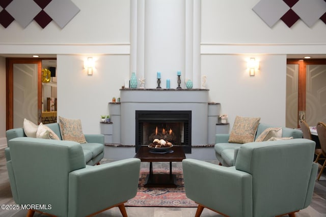 living room with high vaulted ceiling and a lit fireplace