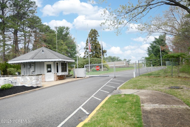 view of road with a gate, a gated entry, and street lights
