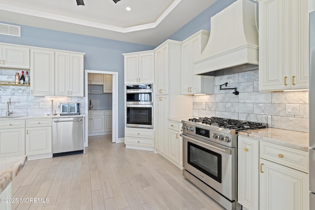 107 Bay Shore Dr, Toms River, NJ 08753 - kitchen with light stone counters, tasteful backsplash, custom range hood, a sink, and appliances with stainless steel finishes