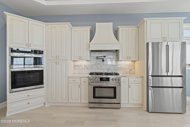 107 Bay Shore Dr, Toms River, NJ 08753 - kitchen featuring tasteful backsplash, light stone countertops, custom range hood, light wood finished floors, and stainless steel appliances