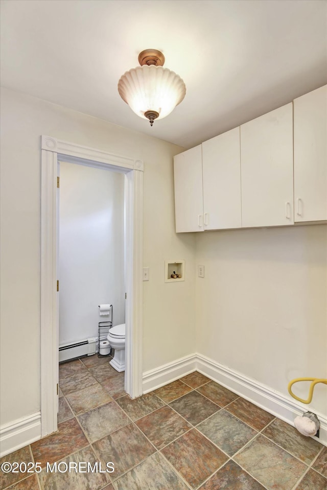 washroom featuring a baseboard heating unit, stone finish flooring, baseboards, and washer hookup