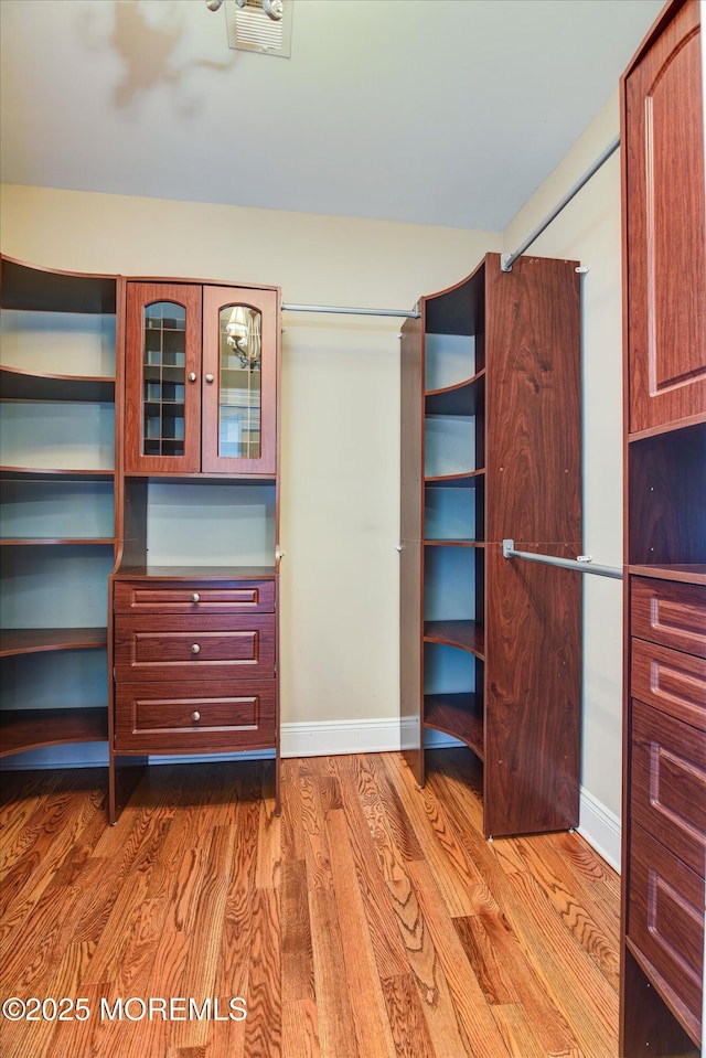 walk in closet featuring visible vents and wood finished floors