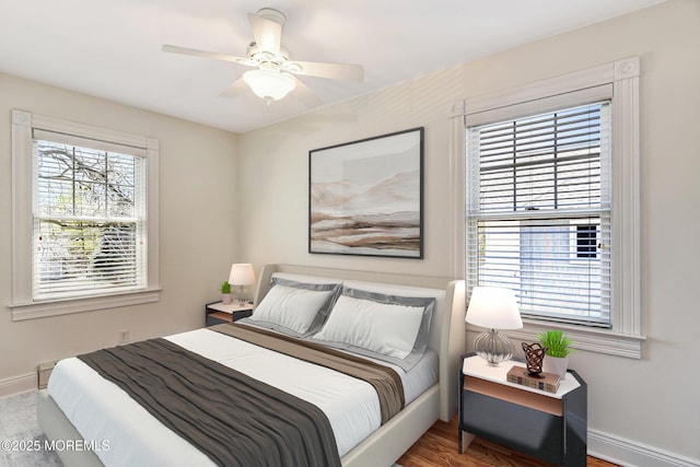 bedroom with baseboards, ceiling fan, and multiple windows
