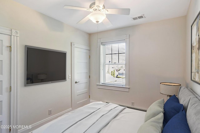 bedroom with a baseboard radiator, a ceiling fan, and visible vents