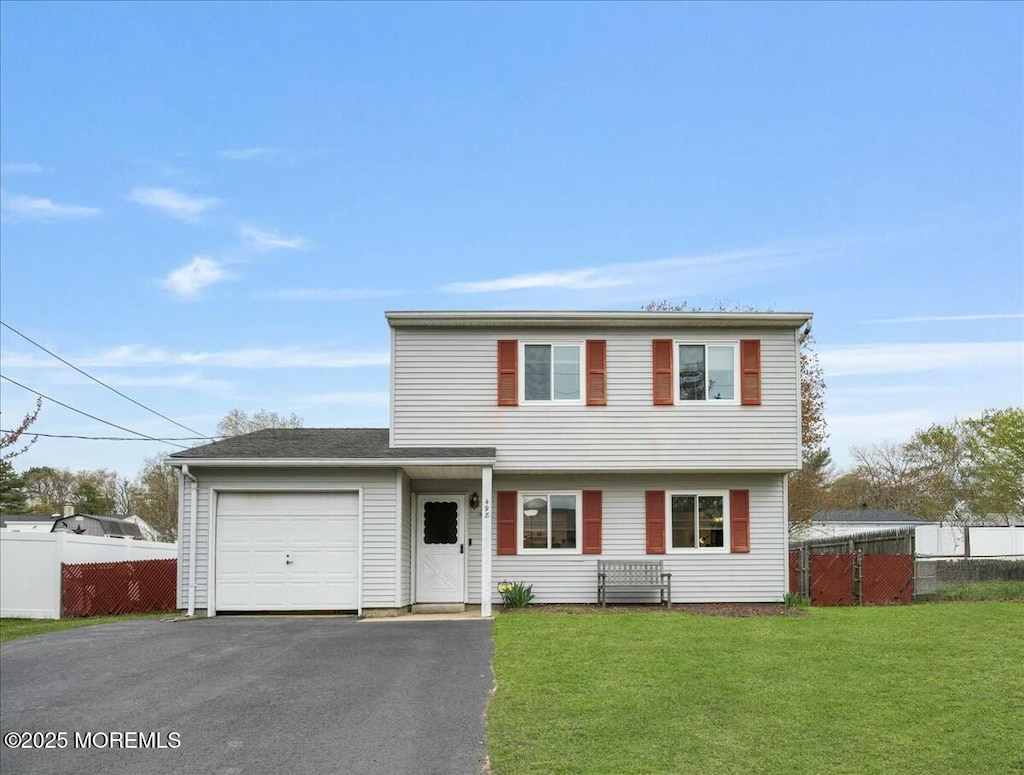 view of front of house with an attached garage, aphalt driveway, a front lawn, and fence