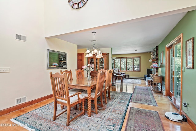 dining room featuring an inviting chandelier, visible vents, light wood-style flooring, and baseboards