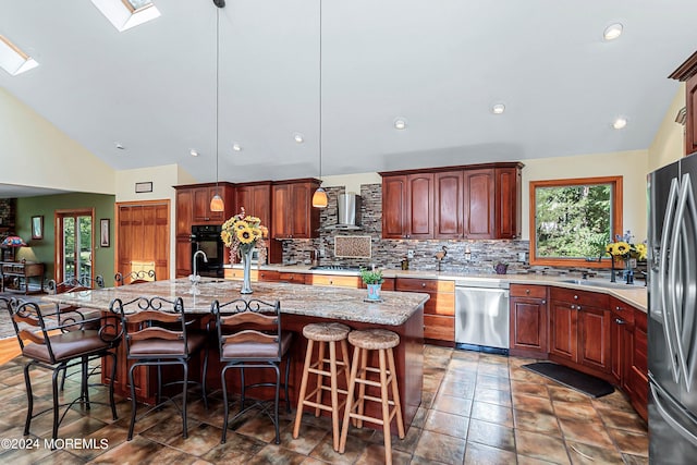kitchen featuring a breakfast bar, stainless steel appliances, backsplash, and wall chimney exhaust hood
