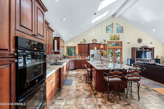 kitchen featuring a breakfast bar area, high vaulted ceiling, dobule oven black, backsplash, and a skylight