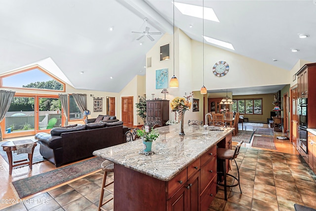 kitchen featuring a skylight, a kitchen breakfast bar, and high vaulted ceiling