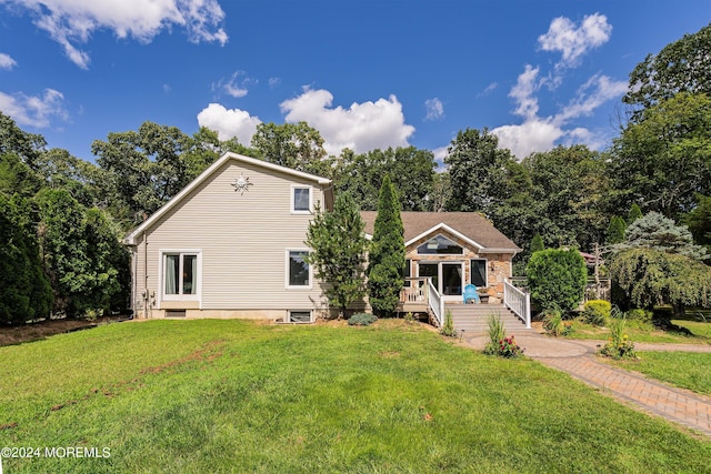 view of front of home featuring a front lawn and a wooden deck