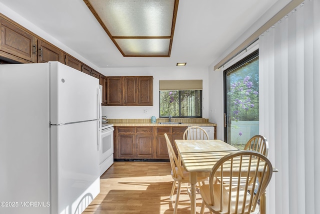 452B Heather Ct, Manchester, NJ 08759 - kitchen with brown cabinetry, white appliances, light countertops, a sink, and light wood-style flooring