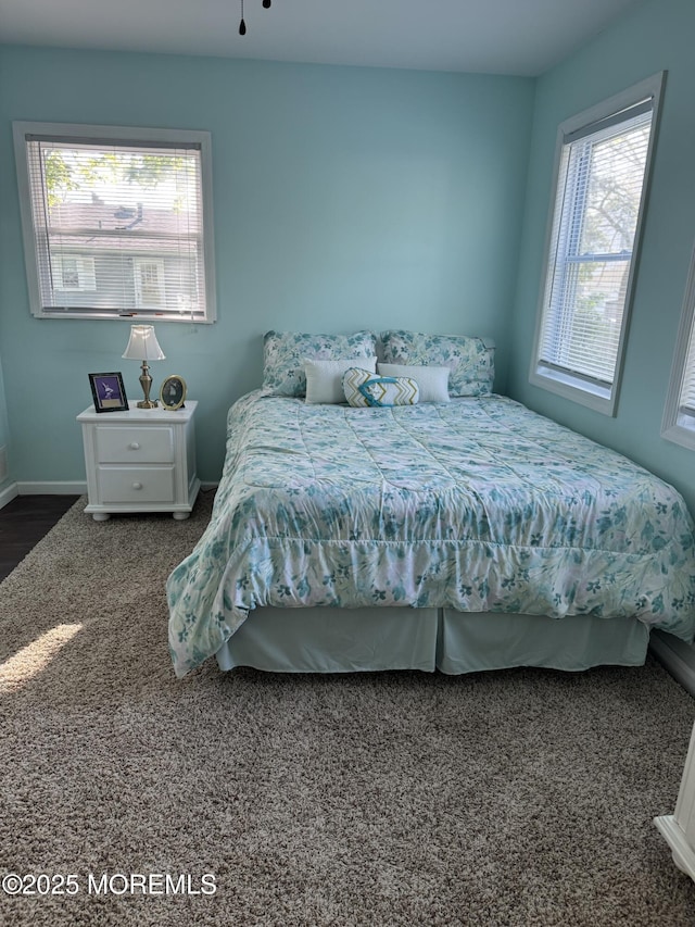 carpeted bedroom with baseboards and multiple windows