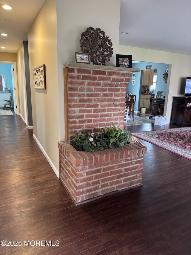 hall featuring baseboards, recessed lighting, and wood finished floors