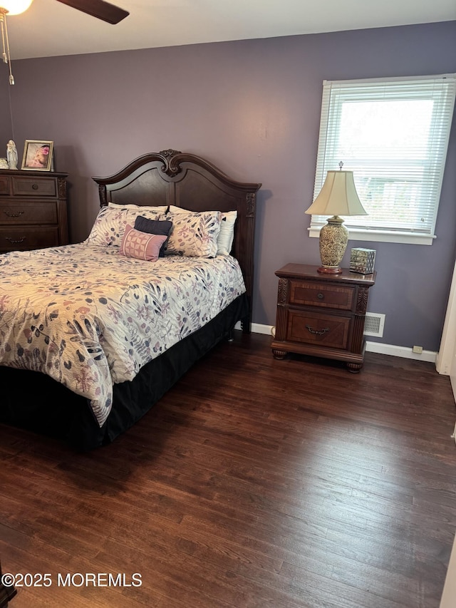 bedroom featuring ceiling fan, baseboards, visible vents, and wood finished floors