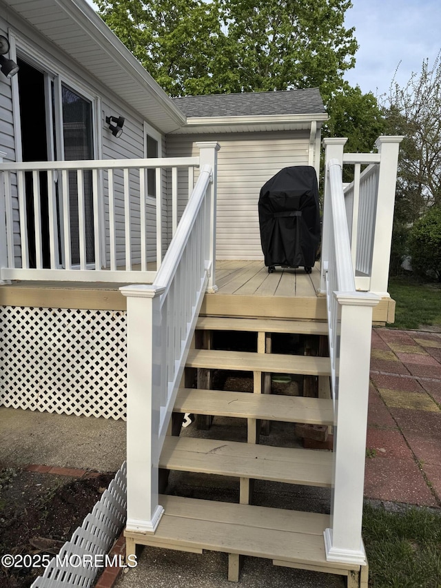 deck with stairs and a grill