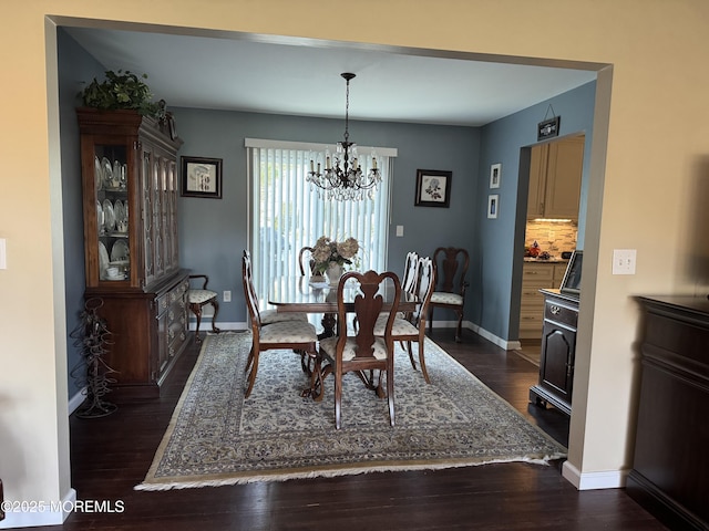 dining room featuring baseboards, a chandelier, and dark wood-style floors