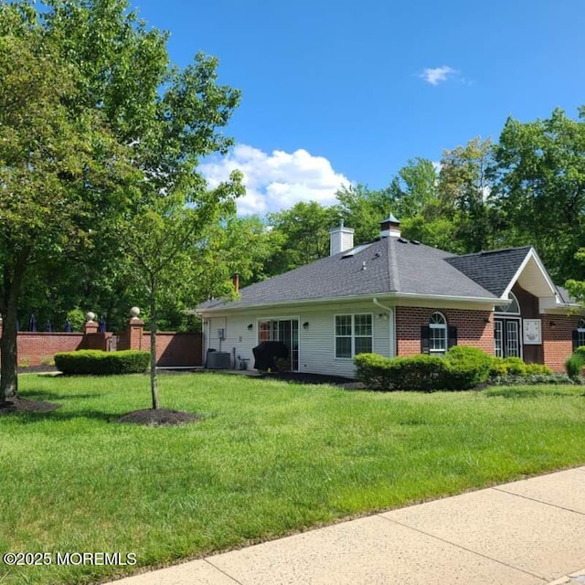 380 Daniele Dr, Ocean Twp, NJ 07712 - ranch-style house with a front yard, brick siding, a chimney, cooling unit, and a shingled roof