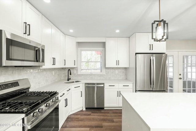 kitchen with stainless steel appliances, a sink, recessed lighting, and dark wood finished floors
