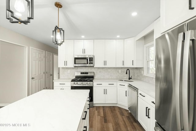 kitchen featuring light countertops, tasteful backsplash, appliances with stainless steel finishes, and a sink