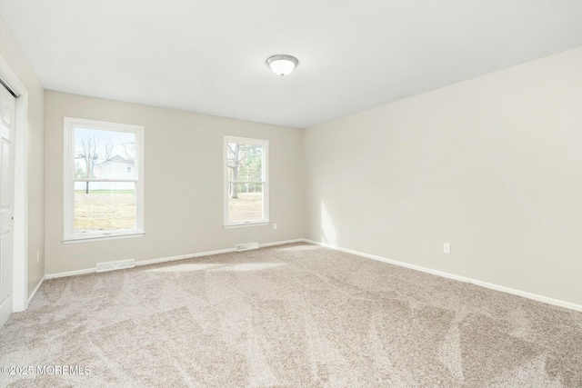 carpeted empty room with baseboards and visible vents