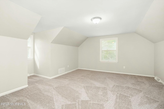 bonus room featuring carpet, visible vents, lofted ceiling, and baseboards
