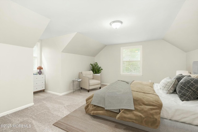 carpeted bedroom with lofted ceiling and baseboards
