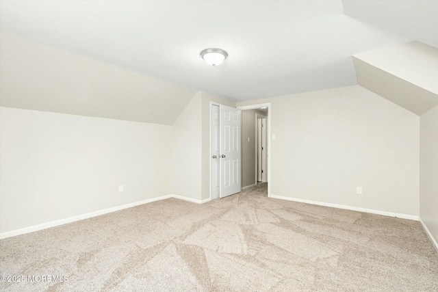 additional living space with baseboards, vaulted ceiling, and carpet flooring