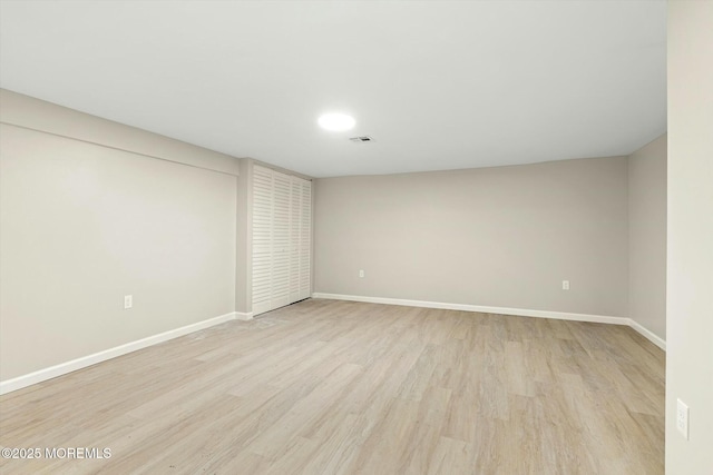 empty room featuring baseboards, light wood-style flooring, and visible vents