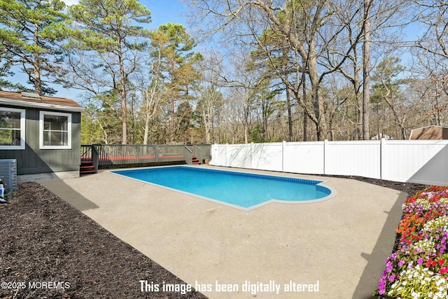 view of swimming pool featuring a fenced backyard, a wooden deck, a patio, and a fenced in pool