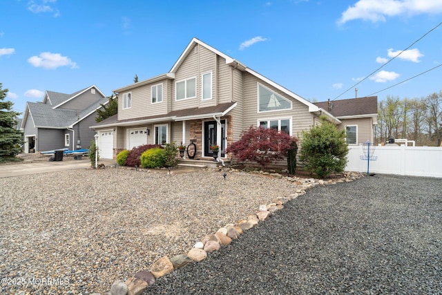 traditional-style house with fence, a porch, and concrete driveway