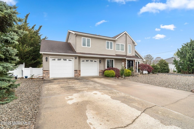 traditional-style home with concrete driveway, stone siding, roof with shingles, fence, and a garage