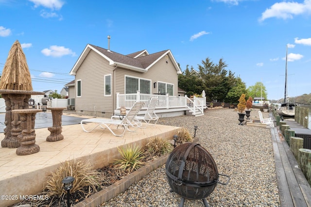 rear view of property featuring an outdoor fire pit, crawl space, a wooden deck, and a patio area
