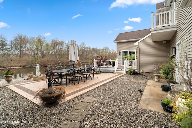 view of patio featuring outdoor dining space and a deck with water view