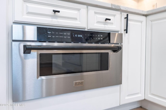 interior details with stainless steel oven and white cabinetry