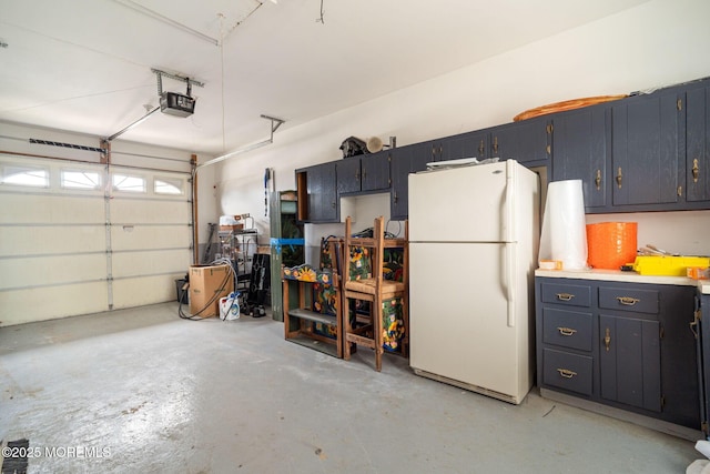 garage featuring a garage door opener and freestanding refrigerator