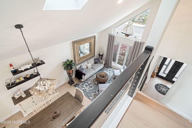 interior space featuring wood finished floors, baseboards, and a skylight