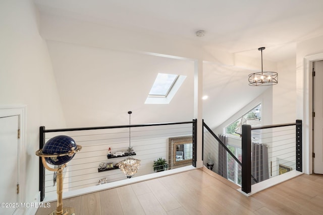 bonus room with wood finished floors, high vaulted ceiling, and a skylight
