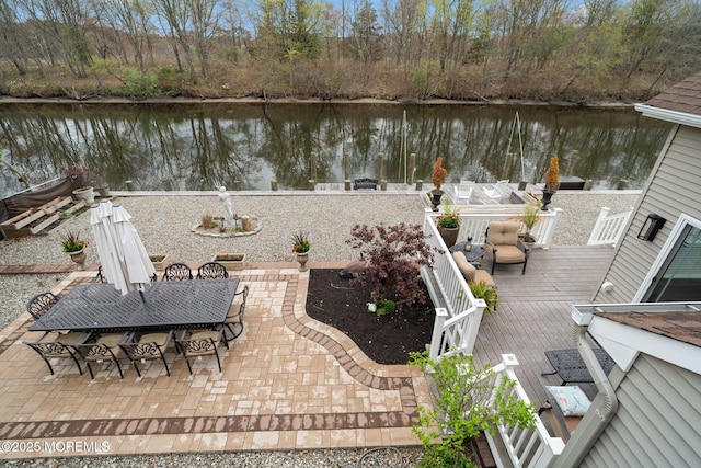 view of patio / terrace with outdoor dining area and a deck with water view