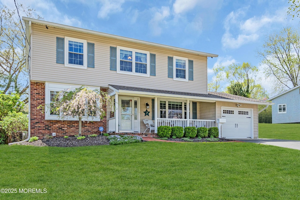 view of front facade with a porch, a front lawn, driveway, and a garage