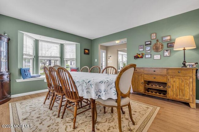dining area featuring a healthy amount of sunlight, baseboards, and light wood-style flooring