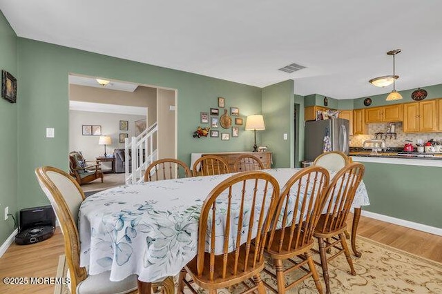 dining room featuring light wood-style floors and visible vents